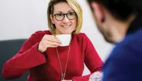 Lady holding a mug during an informal meeting