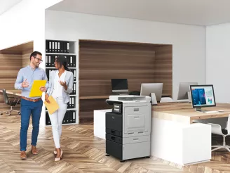 Two colleagues walking past a printer in the office