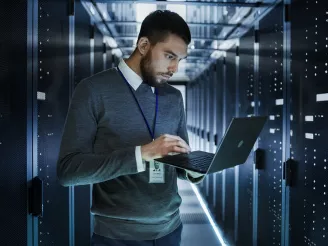 IT technician with laptop in data centre