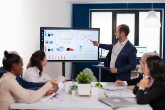 4 people having a meeting whilst looking at a Sharp AV