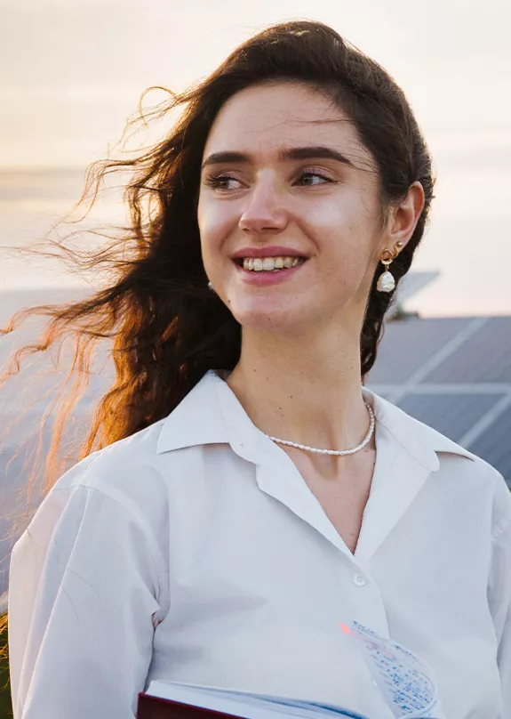 woman investor in front of PV power plant at sunset