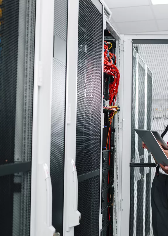Two people working in server room with laptop