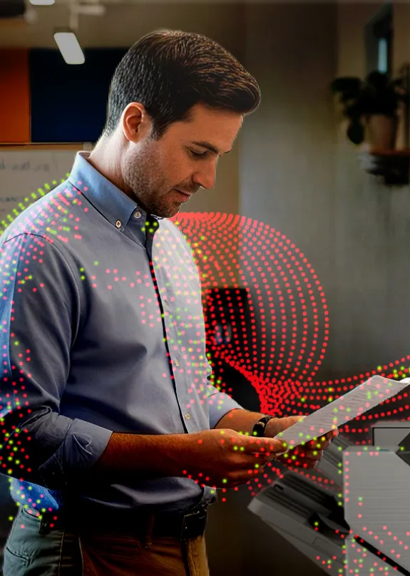Man looking at printed pages of paper from a Sharp MFP